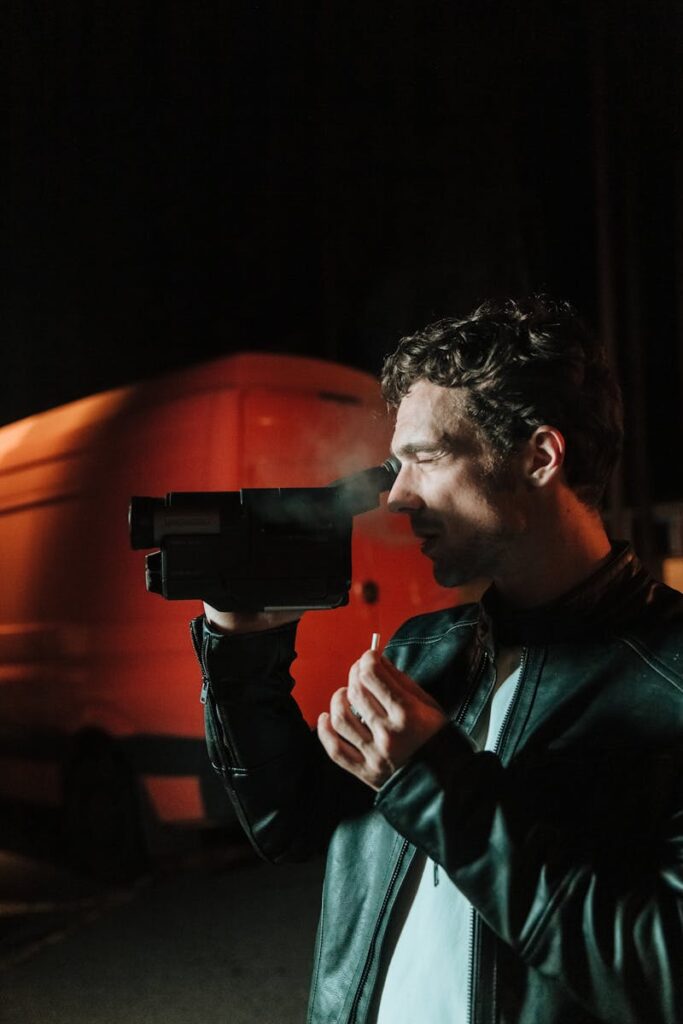 A Man Wearing Black Leather Jacket with a Video Recorder